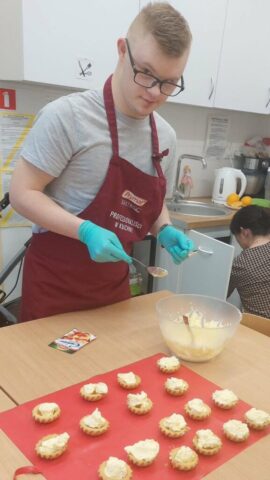 przygotowania dzien kobiet Uczestnik zajęć kulinarnych przygotowuje babeczki podczas nauki zawodu cukiernika w OREW w Sadlnie